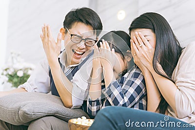 Asian family watching scary movies at home. Stock Photo