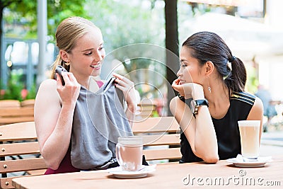 Asian fashionable young woman showing to her best friend a new t Stock Photo