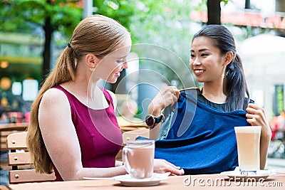 Asian fashionable young woman showing to her best friend a new t Stock Photo