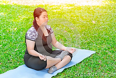 Asian fat plus size girl sitting Yoga on mat Stock Photo