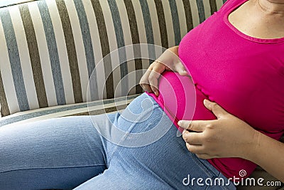 Asian fat women wear pink t shirt . She has overweight and she shows excess fat of the waist. Stock Photo