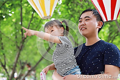 Asian Father embrace hug daughter dad love girl child play have fun in a park outdoor summer day family activity happy childhood Stock Photo