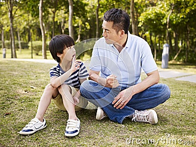 Asian father and son having a conversation Stock Photo