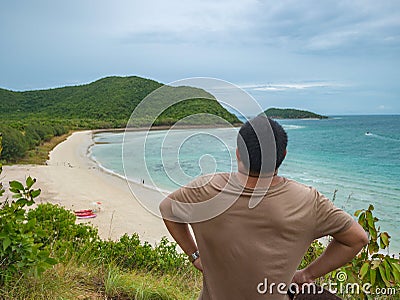 Asian fatty backpacker stand on view point on top of the island with idyllice beach ocean and blue sky in vacation time Stock Photo