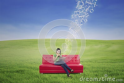 Asian female chatting online with flying letters outdoor Stock Photo