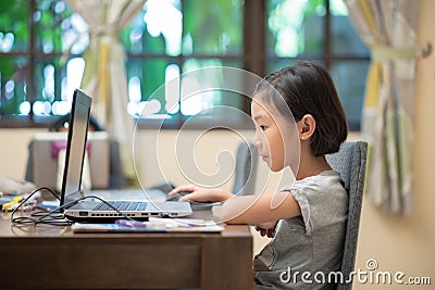 Asian female child doing online learning or e-learning at home Stock Photo