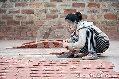 Asian female crafswoman processing ceramic brick Editorial Stock Photo