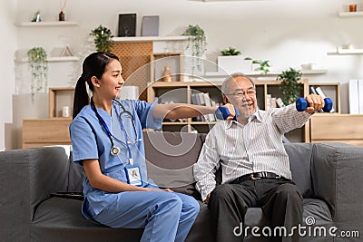 Asian female doctor advice elderly patient to physiotherapist to exercise with dumbbell at home.Smiling nurse helping senior Stock Photo