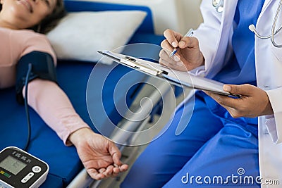 Asian female doctor talks to patient with smile to encourage patient at hospital An elderly Stock Photo