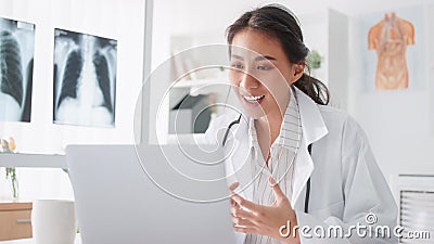 Asian female doctor using laptop computer online video call remote talking to patient Stock Photo