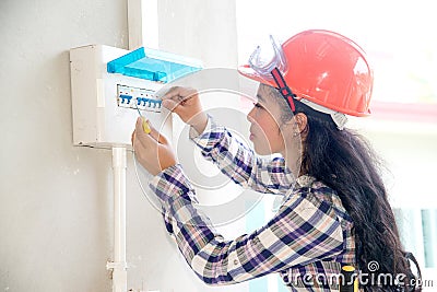 Asian female Electrician or Engineer check or Inspect Electrical system circuit Breaker. Stock Photo