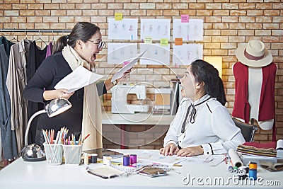 An Asian female fashion tailor team celebrates dress design work success Stock Photo