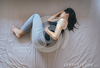 Asian female having painful stomachache,Woman suffering from abdominal pain,Period cramps Stock Photo