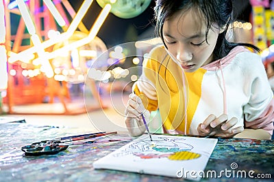 Asian female people is concentrating on paint and determined to learn art,happy teenage girl with palette and paintbrush to Stock Photo