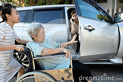 Asian female people enjoy talking on the phone,opening the door car slamming the leg of elderly feel pain,.inattentive girl Stock Photo