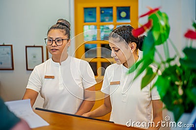 Asian female receptionists during duty hours at the tropical resort Editorial Stock Photo