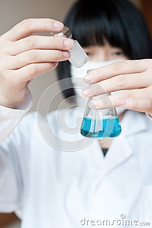 Asian female researcher holding a reagent bottle Stock Photo