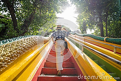 Asian female tourists walking up colorful stairs at Wat Tham Seua, Kanchanaburi, Thailand Stock Photo