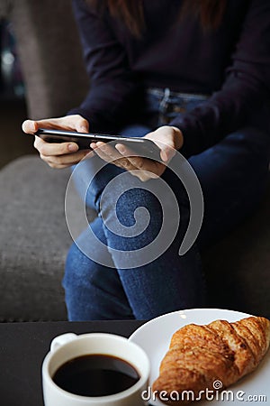 Asian female typing text message with coffe and Croissant Stock Photo