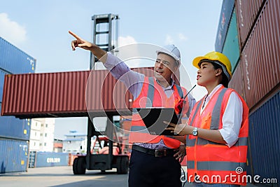 Asian female worker is explaining a check list of container inspections to the supervisor in container depot terminal Stock Photo