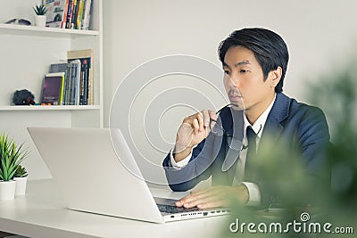 Asian Financial Advisor or Asian Consulting Businessman Serious with Financial Information in Home Office Stock Photo