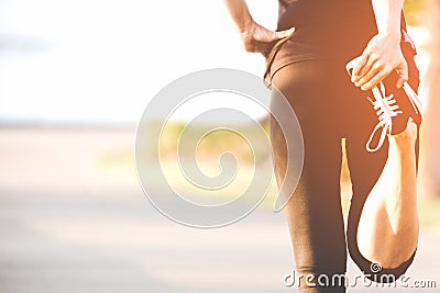 Asian fitness woman runner stretching legs before run outdoor workout in the park. Stock Photo