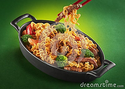 Asian food. Noodles with beef, broccoli, carrot in the metal pan. Doshirak with meat Stock Photo