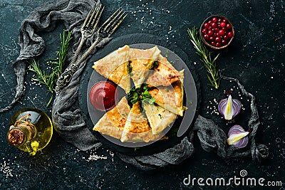 Asian food. Samsa with chicken and cheese on a black stone plate with ketchup. Rustic style. Stock Photo