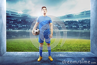 Asian football player man holding the ball in the stadium hallway Stock Photo