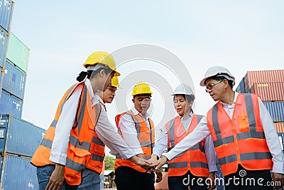 Asian foreman and his team worker standing hands holding together at the container depot terminal for unity and success concept Stock Photo