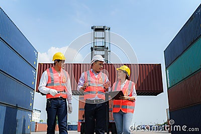 Asian foreman walking and explaining the various operations in the container depot terminal to worker Stock Photo