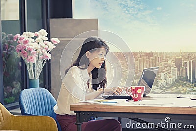 Asian freelancer working on computer laptop against urban office Stock Photo