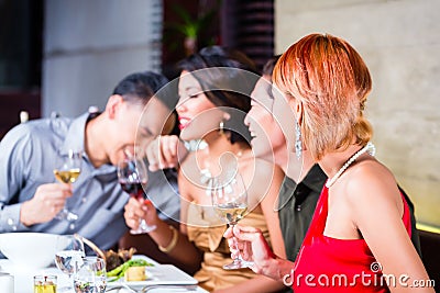 Asian friends dining in fancy restaurant Stock Photo