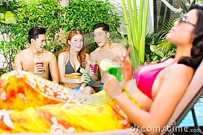 Asian friends partying at pool party in resort Stock Photo