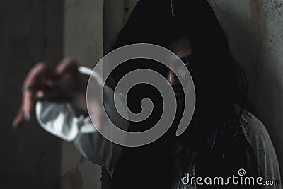 Asian ghost or zombie horror creepy scary have hair covering face and eye reach arm out Stock Photo