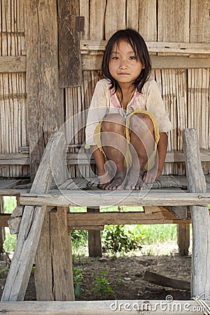 Asian girl Akha before timber house, Laos Stock Photo