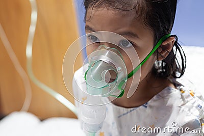 Asian girl has asthma or pneumonia disease and need nebulization by get inhaler mask on her face Stock Photo