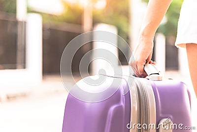 Asian girl has holding big purple bag for come back from travel Stock Photo