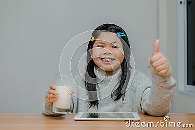 Asian girl having milk before bed smiling happily Stock Photo