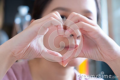 Asian girl and heart hand sing Stock Photo