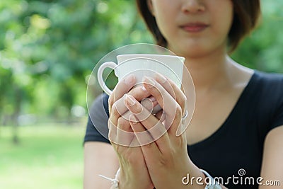 Asian girl hold a cup of coffee with her hand Stock Photo