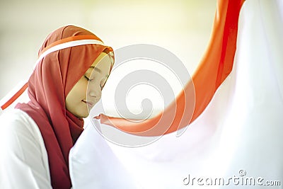 Asian Girl Kissing Indonesian flag, Indonesia independence day Stock Photo