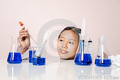 Asian girl playing as a scientist to experiment with laboratory equipment Stock Photo