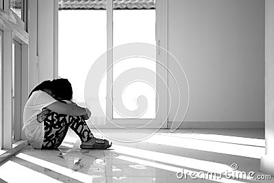 Asian girl sitting on floor at home. Bullying and isolation concept. Stock Photo