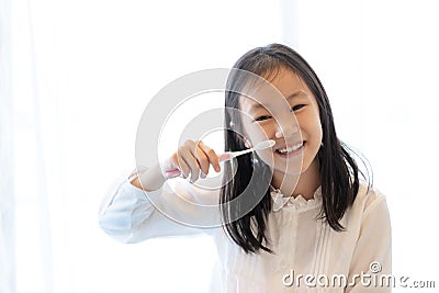 Asian girl smiles and holds a toothbrush on white background,healthy teeth concep Stock Photo