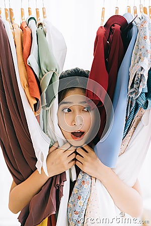 Asian girl stuck in her mess of clothes Stock Photo