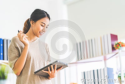 Asian girl working at home office using digital tablet, with copy space. Business owner entrepreneur, small business startup Stock Photo