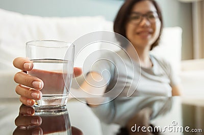 Asian glasses woman holding glass of water Stock Photo