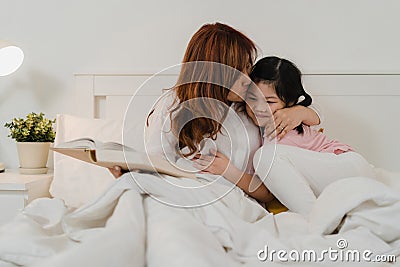 Asian grandmother read fairy tales to granddaughter at home. Senior Chinese, grandma happy relax with young girl enjoy good Stock Photo