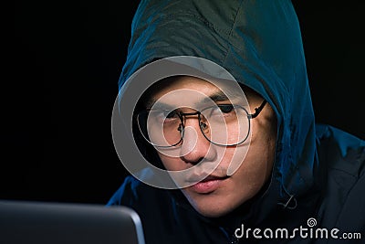 Asian hacker hacking computer network with laptop in dark. Cyber security concept Stock Photo